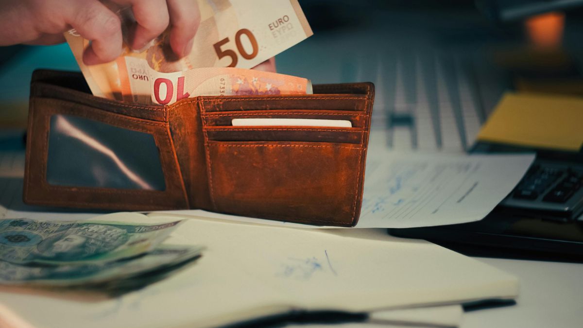 Novčanik s eurima i dokumentima na radnom stolu u Njemačkoj